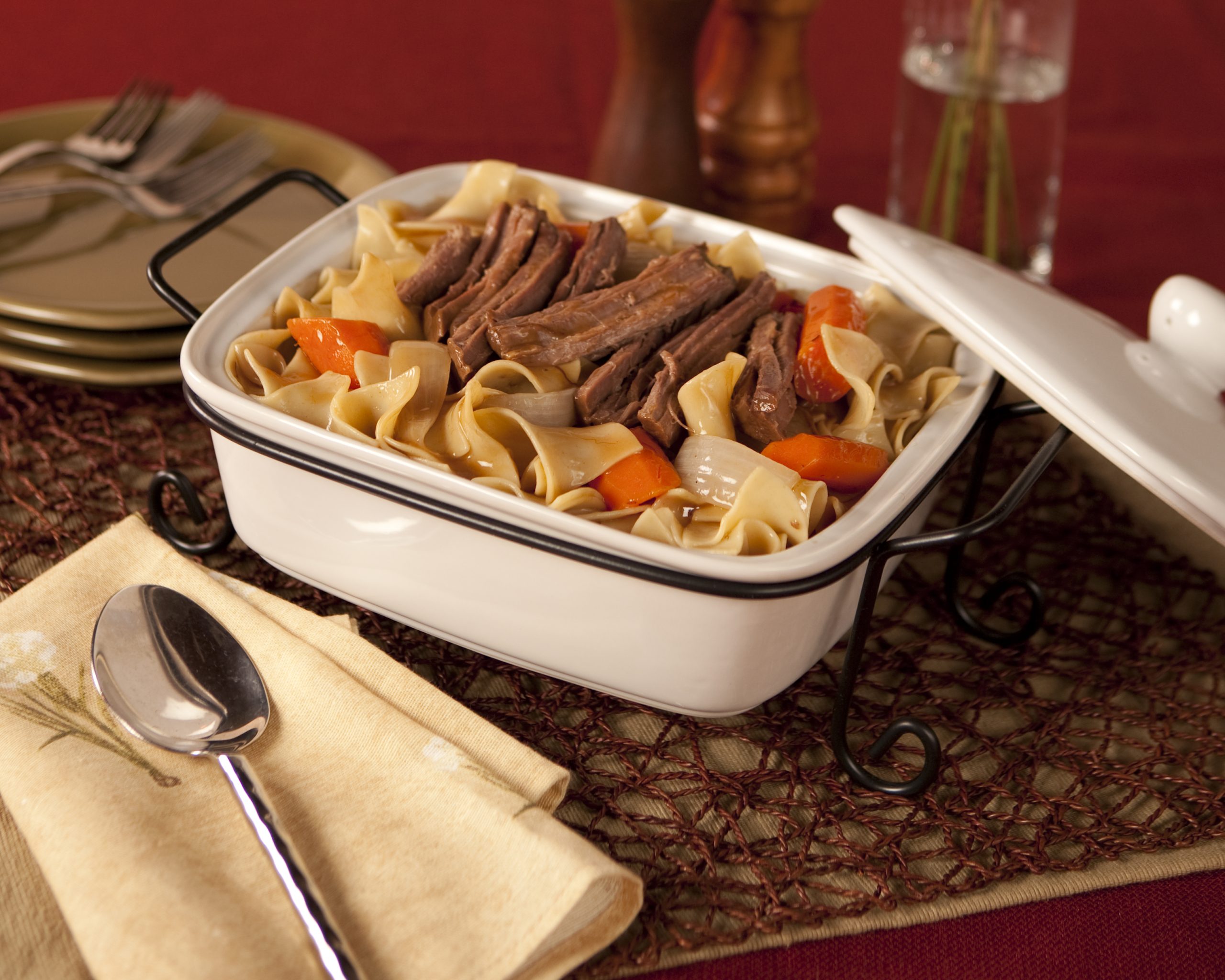 Beef pot roast and wide egg noodles with carrots and onions in a light sauce