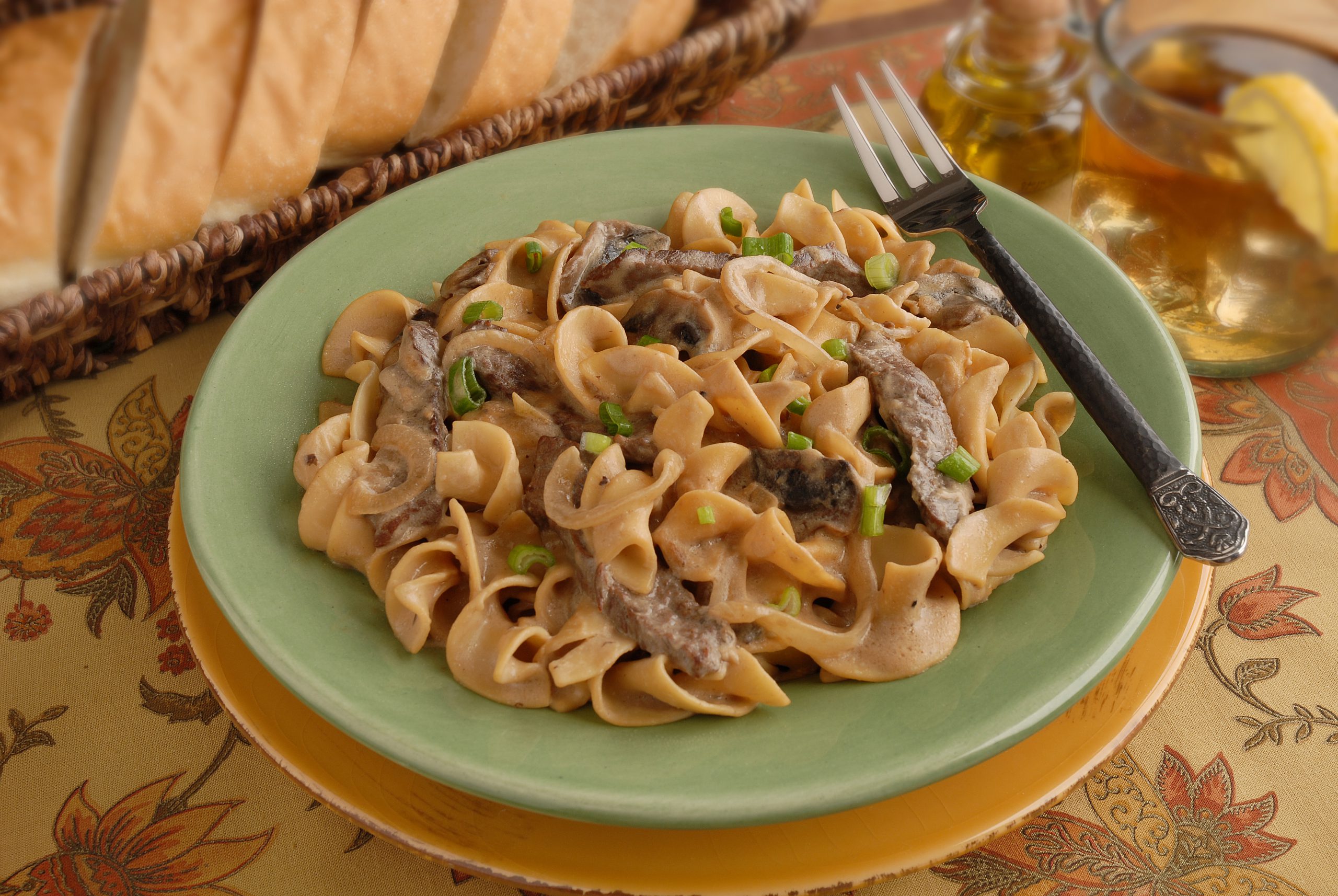 Egg noodles, beef, onions, and mushrooms in a light sauce, topped with fresh green onion