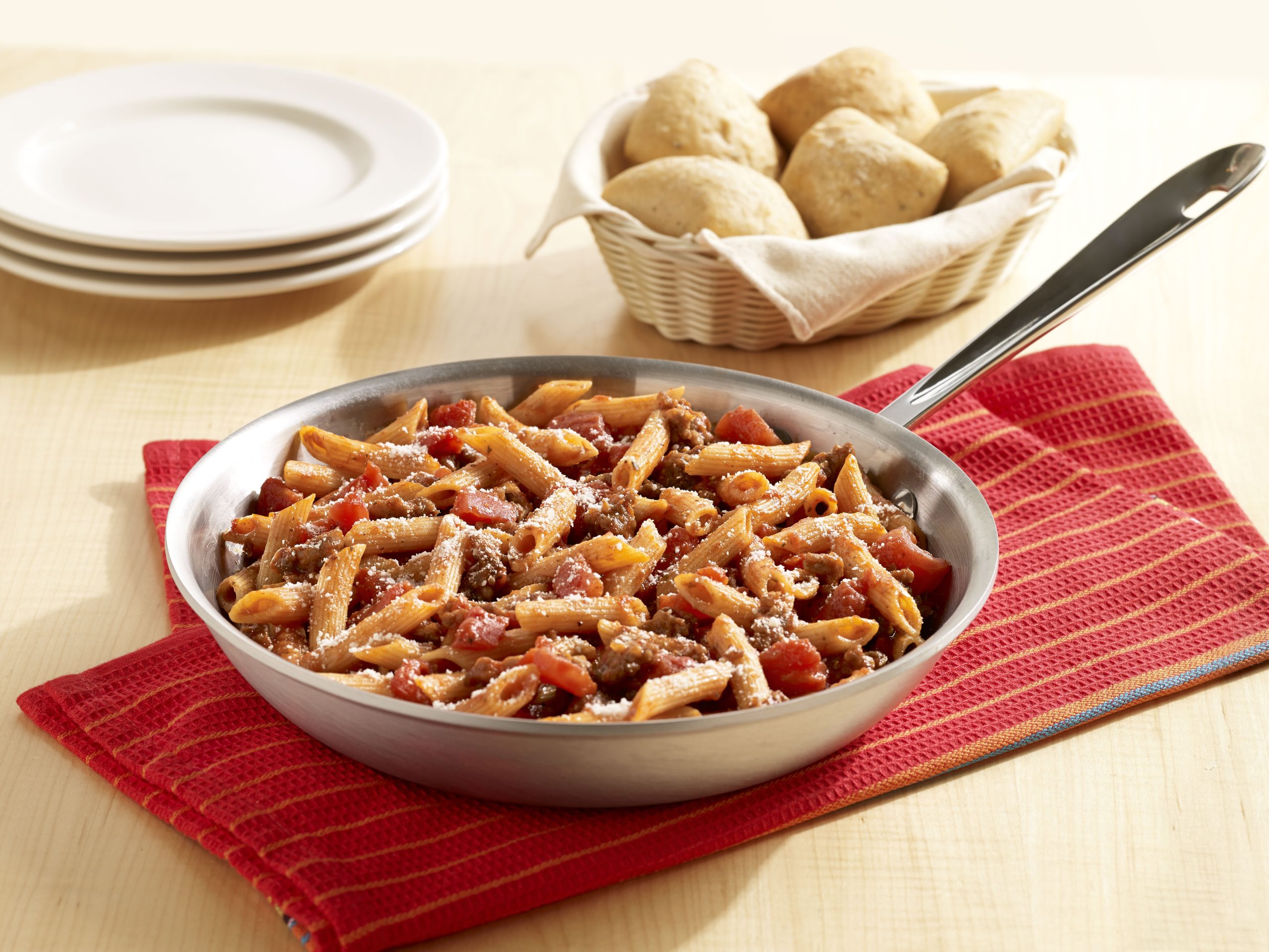 Penne pasta with Italian sausage and tomatoes in a light tomato sauce, sprinkled with Parmesan cheese
