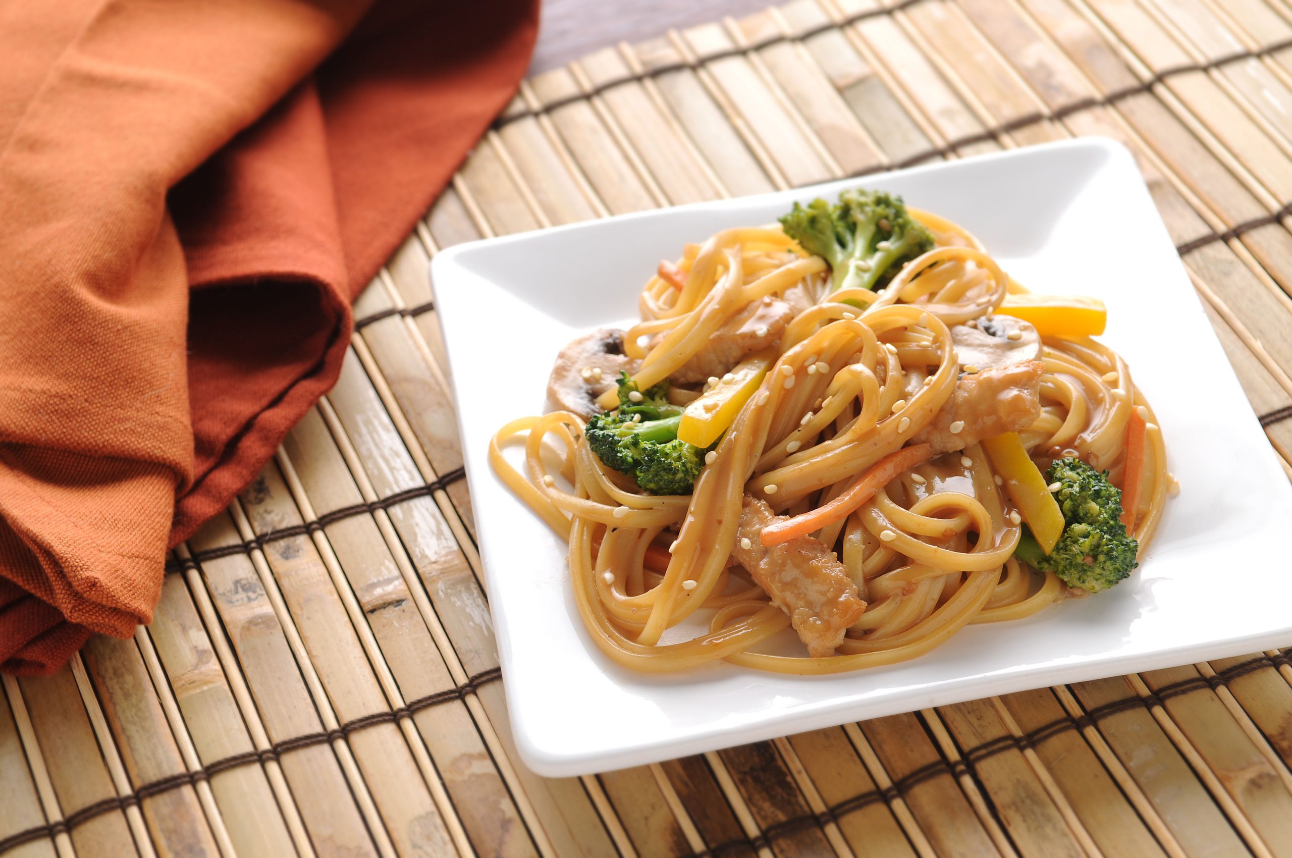 Linguine, pork, carrots, and broccoli coated in an Asian vinaigrette and topped with sesame seeds