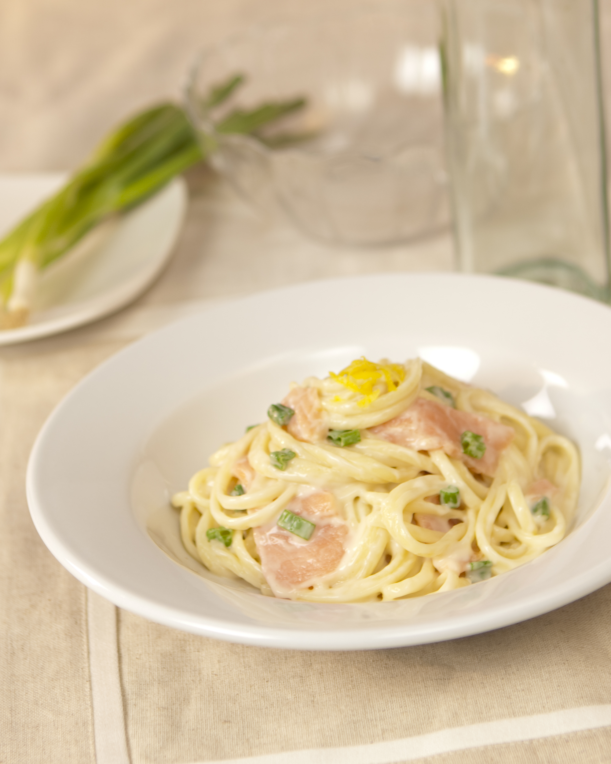 Linguine with smoked salmon coated in Alfredo sauce, topped with lemon zest